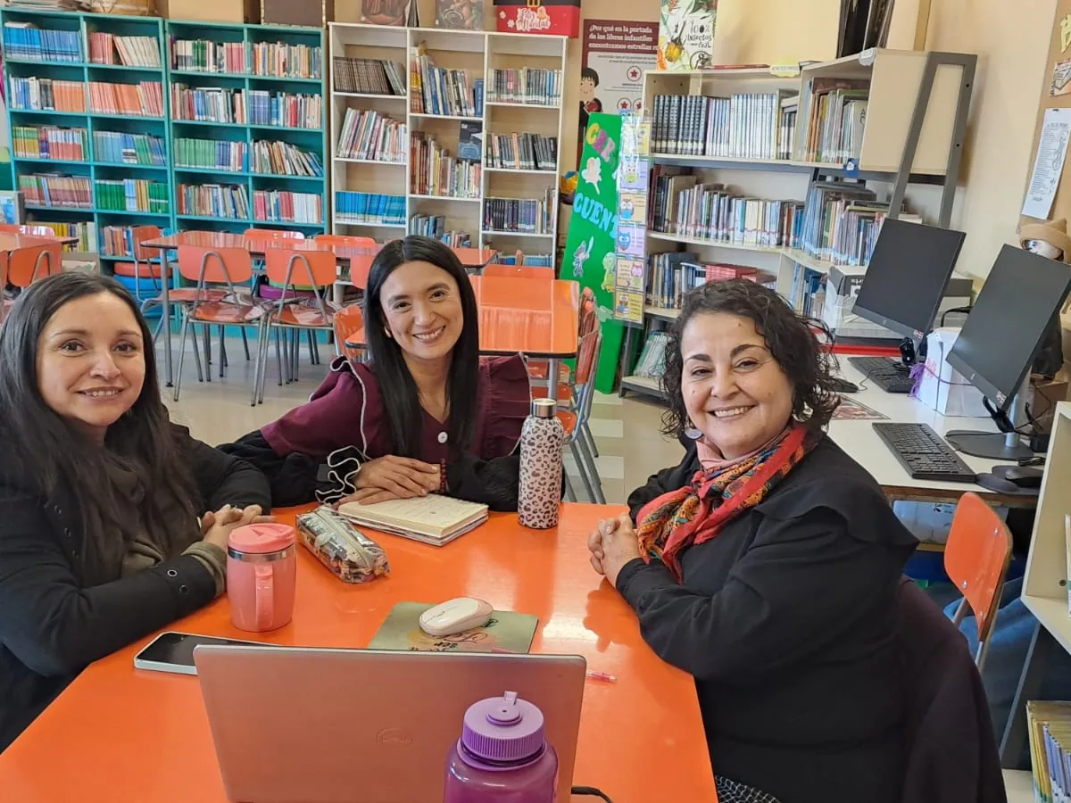 Tres profesoras conversando en la biblioteca del colegio